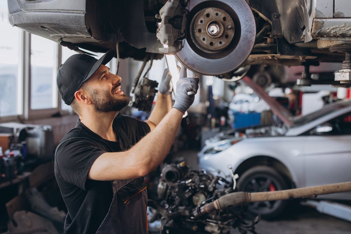 Mechanic inspecting a brake disc on a car during a mobile automotive service in Geelong